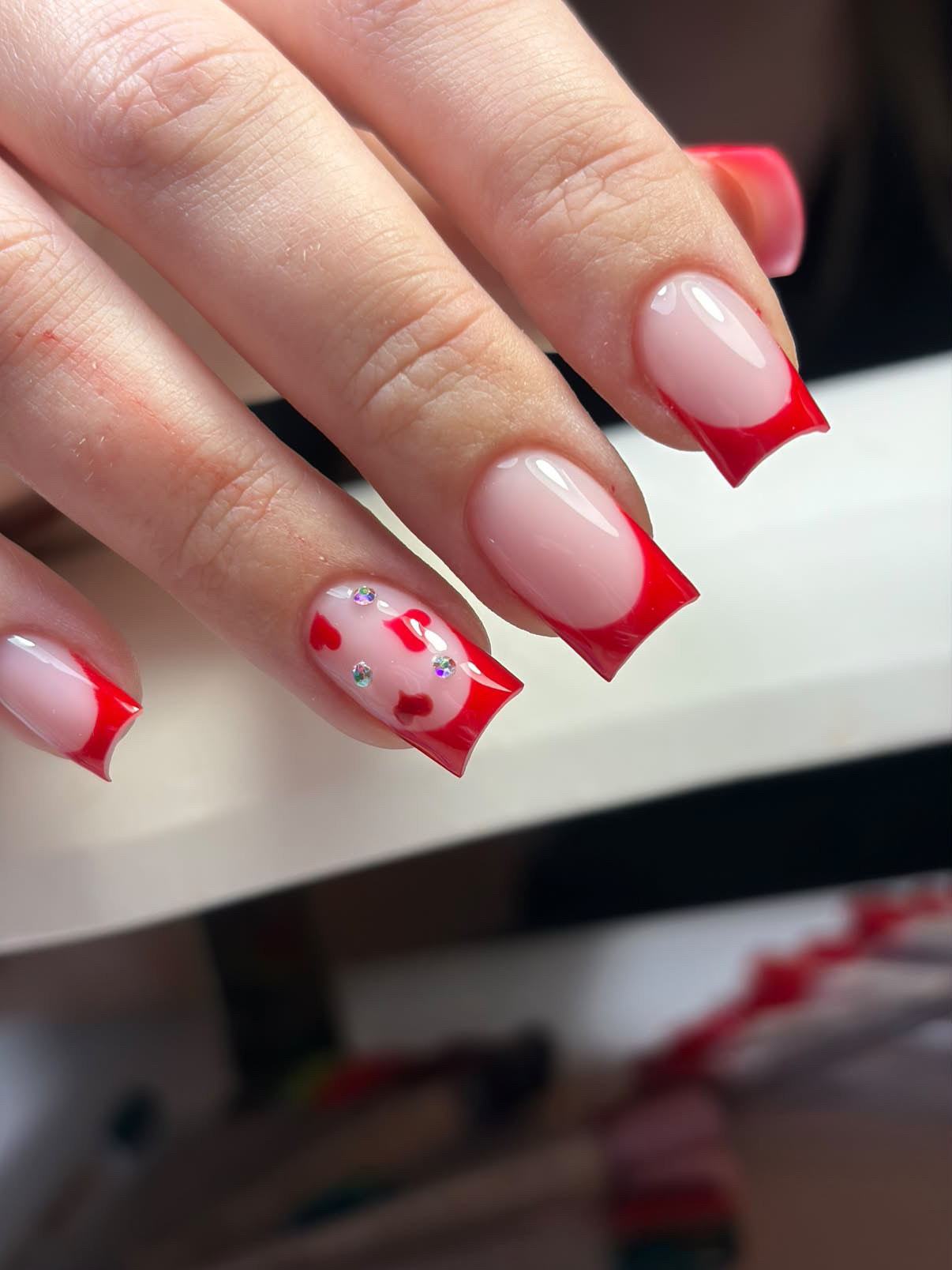 Rote French-Tips mit Herz-Design und Strasssteinen